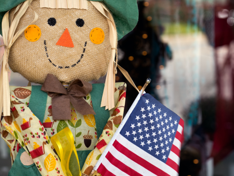 Up-close photo of a scarecrow holding a U.S. flag.